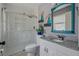 This bathroom features a granite counter, custom mirror, and tiled shower at 13308 Prestwick Dr, Riverview, FL 33579