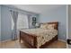This is a nice bedroom with a wooden bed frame, floral bedding, and natural lighting at 13308 Prestwick Dr, Riverview, FL 33579