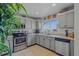 Bright kitchen with stainless steel appliances, light gray cabinetry, and natural light from the window at 13308 Prestwick Dr, Riverview, FL 33579
