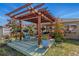 Backyard wooden pergola with flowering vines and outdoor seating at 13308 Prestwick Dr, Riverview, FL 33579