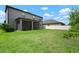 Spacious backyard with lush green lawn and a screened-in patio. White fence in back at 13311 Orca Sound Dr, Riverview, FL 33579