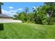 Lush green backyard featuring a well-maintained lawn and partial view of a white fence at 13311 Orca Sound Dr, Riverview, FL 33579