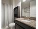 Bathroom featuring granite countertops, black cabinets, and a shower with a gray shower curtain at 13311 Orca Sound Dr, Riverview, FL 33579