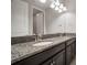 Bathroom featuring double sinks with granite countertops and modern lighting fixture above large vanity mirror at 13311 Orca Sound Dr, Riverview, FL 33579