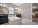Bright bathroom features a soaking tub, granite countertop, and a separate glass-enclosed shower at 13311 Orca Sound Dr, Riverview, FL 33579