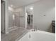 Bright bathroom features a walk-in shower, soaking tub, and access to walk-in closet at 13311 Orca Sound Dr, Riverview, FL 33579