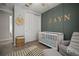 Bedroom featuring a white crib, comfortable glider, and decorative 'Zayn' wall art at 13311 Orca Sound Dr, Riverview, FL 33579