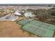 An aerial view showing community tennis courts, basketball court, a pool and a clubhouse, with a parking lot and surrounding greenery at 13311 Orca Sound Dr, Riverview, FL 33579