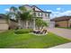 Beautiful lawn showcasing lush landscaping and a charming gray two-story home with a three-car garage at 13311 Orca Sound Dr, Riverview, FL 33579