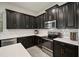 Contemporary kitchen features black cabinetry, stainless steel appliances, and bright white subway tile backsplash at 13311 Orca Sound Dr, Riverview, FL 33579