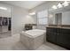 Luxurious bathroom featuring a soaking tub, dual vanities, and stylish fixtures, plus closet access at 13311 Orca Sound Dr, Riverview, FL 33579