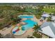 Aerial view of the community pool with a splash pad, regular swimming pool, and tennis courts in the background at 13311 Orca Sound Dr, Riverview, FL 33579