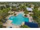 Aerial view of a community pool featuring palm trees, lounge chairs, and a covered seating area at 13311 Orca Sound Dr, Riverview, FL 33579
