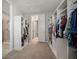 Bright walk-in closet with extensive shelving and rack space for optimal storage organization at 13311 Orca Sound Dr, Riverview, FL 33579
