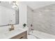 Updated bathroom features a modern vanity, sleek mirror, and tub with marble-look tile surround at 13612 Veronica Dr, Hudson, FL 34667