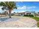 Charming home with a circular driveway and mature palm tree in the front yard at 13612 Veronica Dr, Hudson, FL 34667