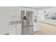 Stainless steel refrigerator and modern cabinets in updated kitchen with tile floors at 13612 Veronica Dr, Hudson, FL 34667