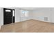 Bright living room with wood-look tile flooring, large windows, and a modern front door at 13612 Veronica Dr, Hudson, FL 34667