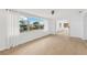 Bright living room with view to another room and large windows overlooking waterfront at 13612 Veronica Dr, Hudson, FL 34667