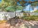 Serene backyard featuring a patio table with a green umbrella, seating, and mature landscaping at 1432 Windjammer Pl, Valrico, FL 33594