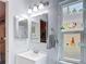 Bright bathroom with patterned mirror, vanity, and decorative shelving unit next to the window at 1432 Windjammer Pl, Valrico, FL 33594