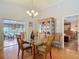 Dining room with glass top table and chairs, chandelier lighting, and sliding door to screened patio at 1432 Windjammer Pl, Valrico, FL 33594