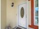 Close-up of the white front door with an oval glass insert and a decorative light fixture at 1432 Windjammer Pl, Valrico, FL 33594