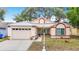 Charming one-story home with a metal roof, well-kept landscaping, and an attached two-car garage at 1432 Windjammer Pl, Valrico, FL 33594