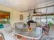 Covered lanai with an outdoor dining set, ceiling fan, and access to a well-manicured backyard at 1432 Windjammer Pl, Valrico, FL 33594
