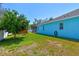 Expansive backyard with lush greenery, a shed, and the home's exterior under a bright sky at 1709 Sunset Dr, Tarpon Springs, FL 34689