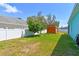 Spacious backyard featuring a shed, mature trees, and a well-manicured lawn at 1709 Sunset Dr, Tarpon Springs, FL 34689