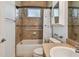 Bright bathroom featuring a shower-tub combo, commode, decorative mosaic, and a vanity at 1709 Sunset Dr, Tarpon Springs, FL 34689