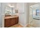 This bathroom features a neutral color scheme, travertine flooring, and a wooden vanity at 1709 Sunset Dr, Tarpon Springs, FL 34689