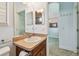 Bright bathroom with tile flooring, a commode, vanity, a decorative mirror, and an arched entryway at 1709 Sunset Dr, Tarpon Springs, FL 34689