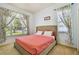 Cozy bedroom with a plush coral bed, large windows offering a bright view, and neutral colored walls at 1709 Sunset Dr, Tarpon Springs, FL 34689