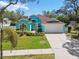 Stunning home with lush landscaping, a well-manicured lawn, and a driveway leading to a two-car garage at 1709 Sunset Dr, Tarpon Springs, FL 34689