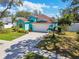 Inviting home with a well-manicured lawn, mature landscaping, and a spacious driveway leading to a two-car garage at 1709 Sunset Dr, Tarpon Springs, FL 34689