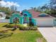 Charming home with verdant landscaping, featuring a well-maintained lawn, garden beds, and a welcoming entrance at 1709 Sunset Dr, Tarpon Springs, FL 34689