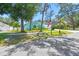 Well-maintained home with mature trees, an American flag, and manicured green space at 1709 Sunset Dr, Tarpon Springs, FL 34689