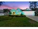 Inviting home featuring a manicured lawn and vibrant exterior, all set against a colorful dusk sky at 1709 Sunset Dr, Tarpon Springs, FL 34689