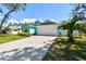 A charming home features a lush green lawn and a pristine, long driveway at 1709 Sunset Dr, Tarpon Springs, FL 34689