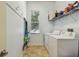 This laundry room features a tile floor, a utility sink, and full size washer and dryer at 1709 Sunset Dr, Tarpon Springs, FL 34689