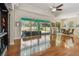 Open living room with wood floors, ceiling fan, and views of screened-in lanai and pool at 1709 Sunset Dr, Tarpon Springs, FL 34689