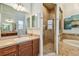 Well-lit main bathroom features travertine tile, a soaking tub, a shower, and a wooden vanity at 1709 Sunset Dr, Tarpon Springs, FL 34689