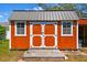 Charming storage shed with double doors, windows, metal roof, and a practical space for tools and equipment at 1709 Sunset Dr, Tarpon Springs, FL 34689