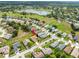 Aerial view of a community with a home highlighted, situated near a pond and meticulously maintained green spaces at 18514 Hidden Pines Way, Hudson, FL 34667