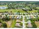 An aerial view shows a vibrant neighborhood near a scenic pond, green spaces, and community amenities at 18514 Hidden Pines Way, Hudson, FL 34667