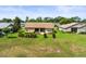 The backyard features green grass and trimmed bushes near a screened lanai, providing a private outdoor space at 18514 Hidden Pines Way, Hudson, FL 34667