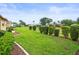 A spacious, green backyard features manicured landscaping with trimmed bushes, mulch, and a concrete border at 18514 Hidden Pines Way, Hudson, FL 34667