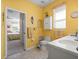 Sunny yellow bathroom with double sinks, adjacent to bedroom at 18514 Hidden Pines Way, Hudson, FL 34667